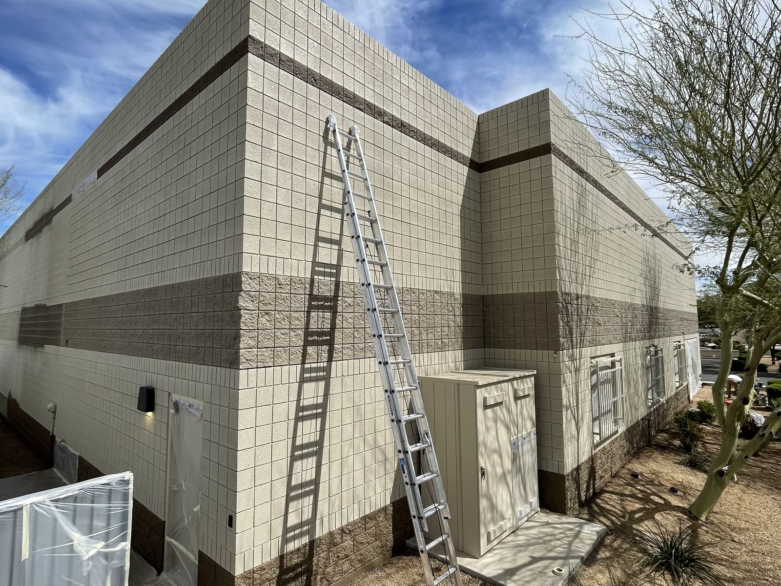 Phoenix commercial block building before repainting, with an extension ladder against the wall