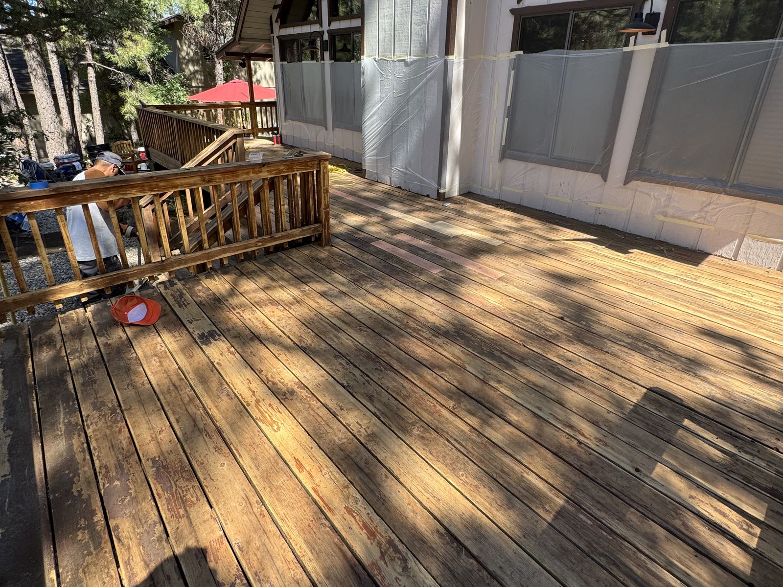 Weathered grey deck boards with worn, patchy stain