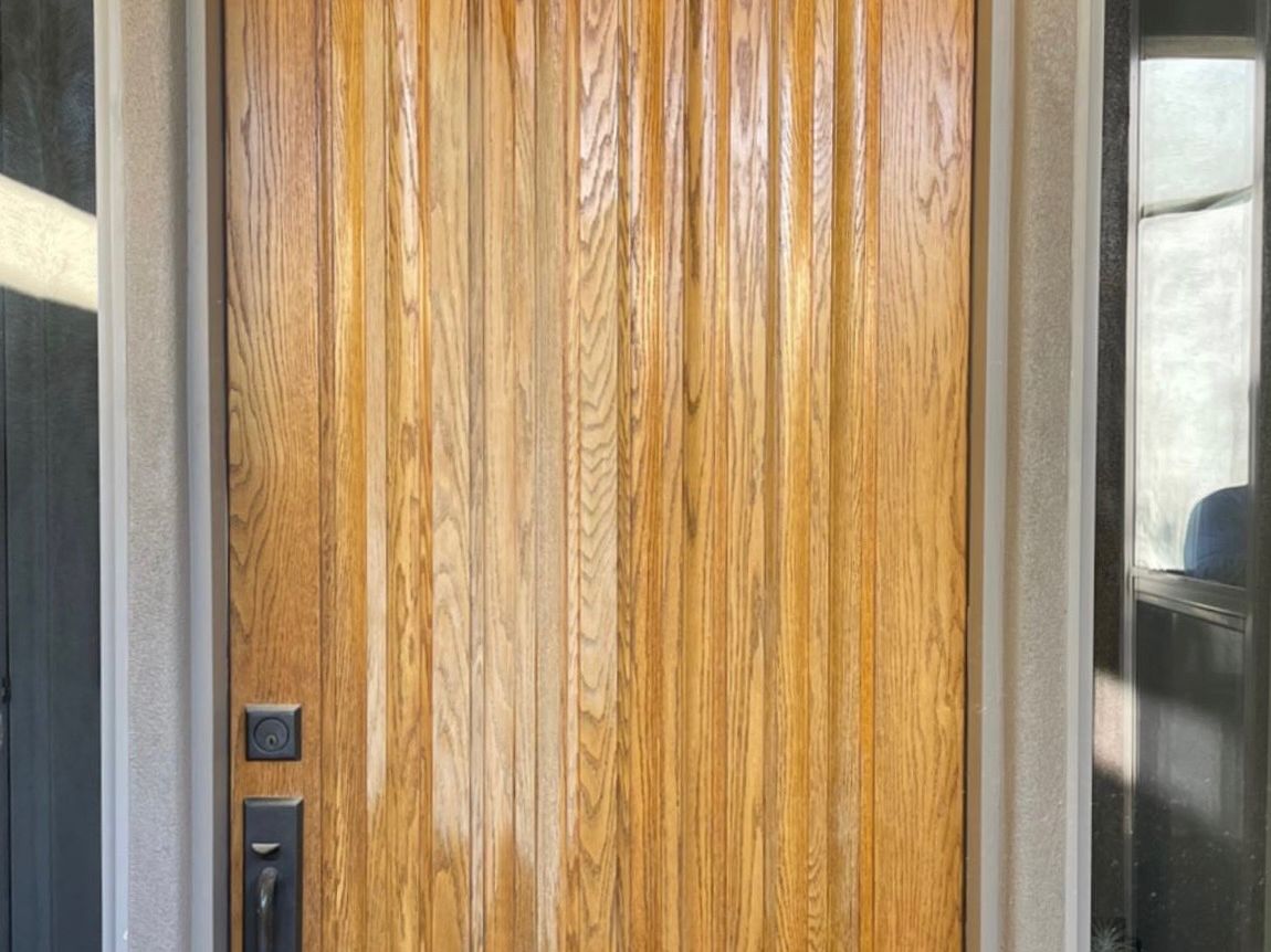 Faded light oak front door with dry, sun-bleached grain