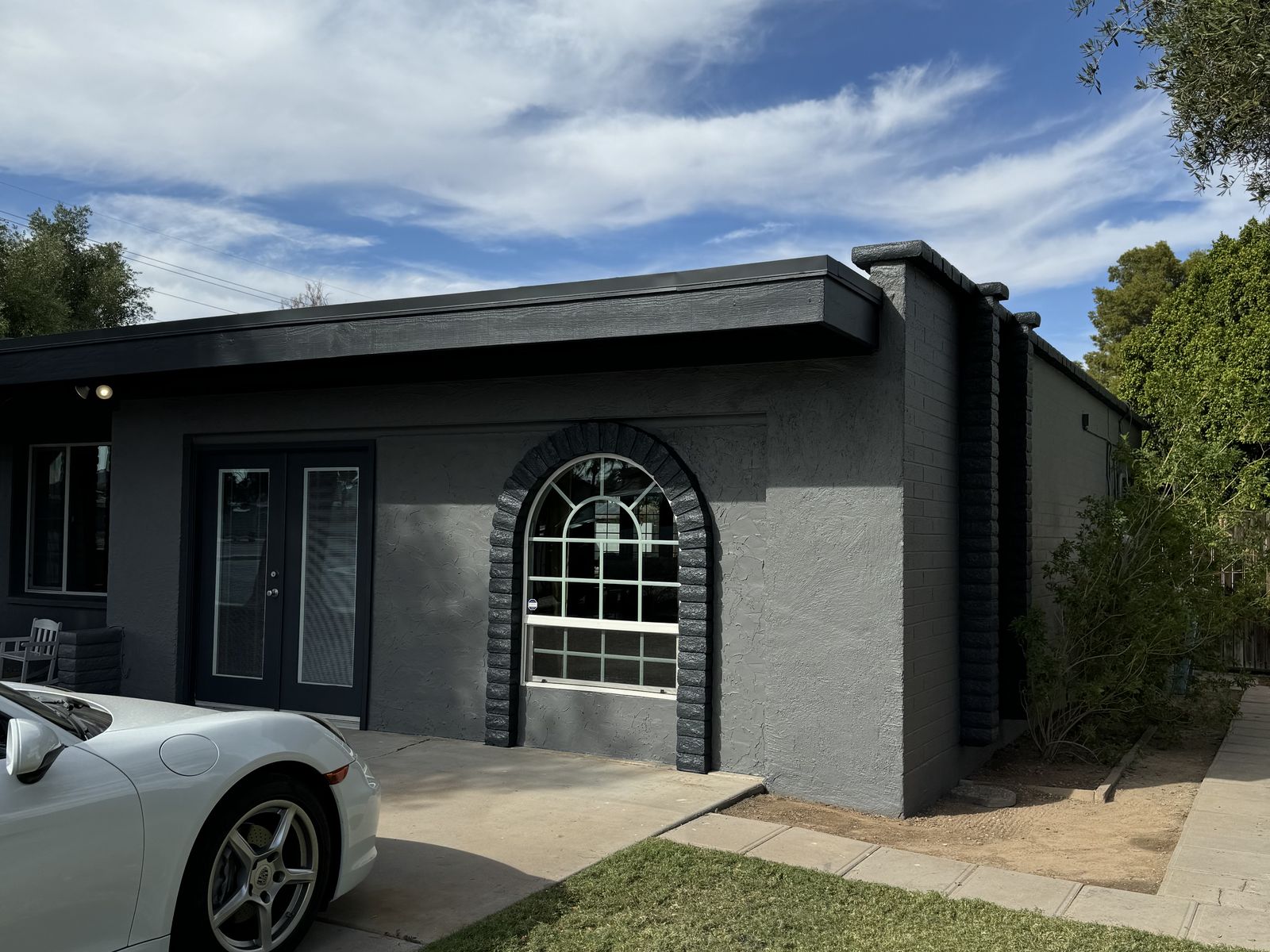 Finished Phoenix home in deep charcoal with white arched window trim