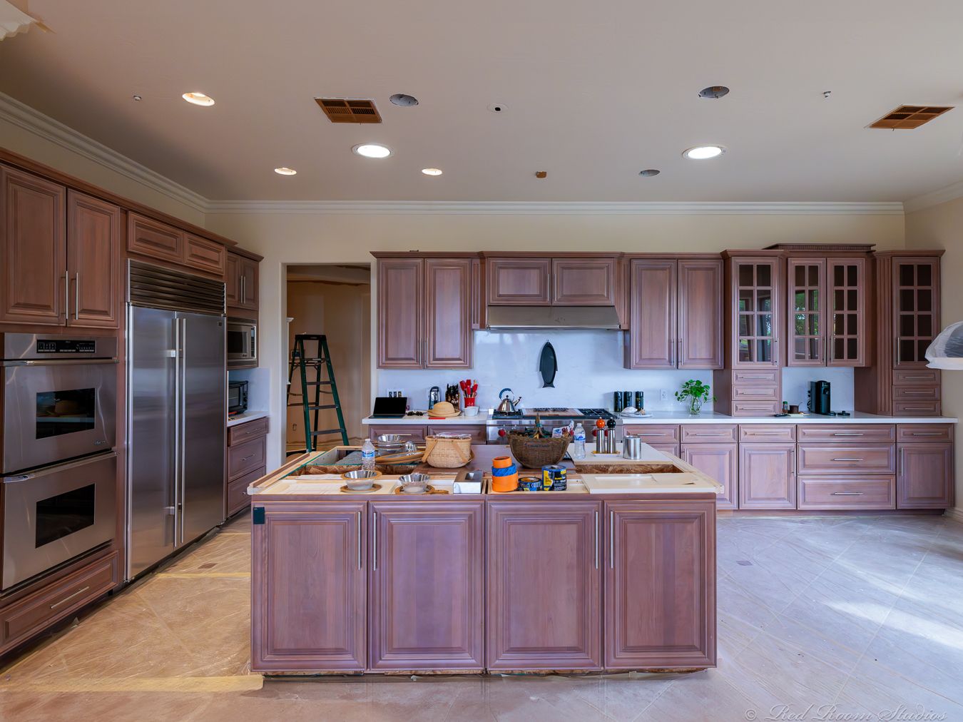 Phoenix kitchen mid-project with cabinets in primer and the floor papered over