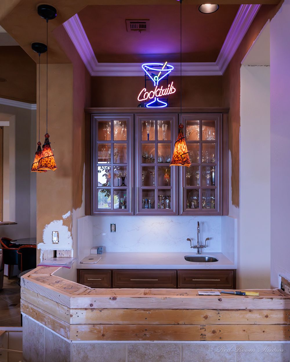 The same wet bar mid-project, cabinets in primer with the counter framed out in raw lumber
