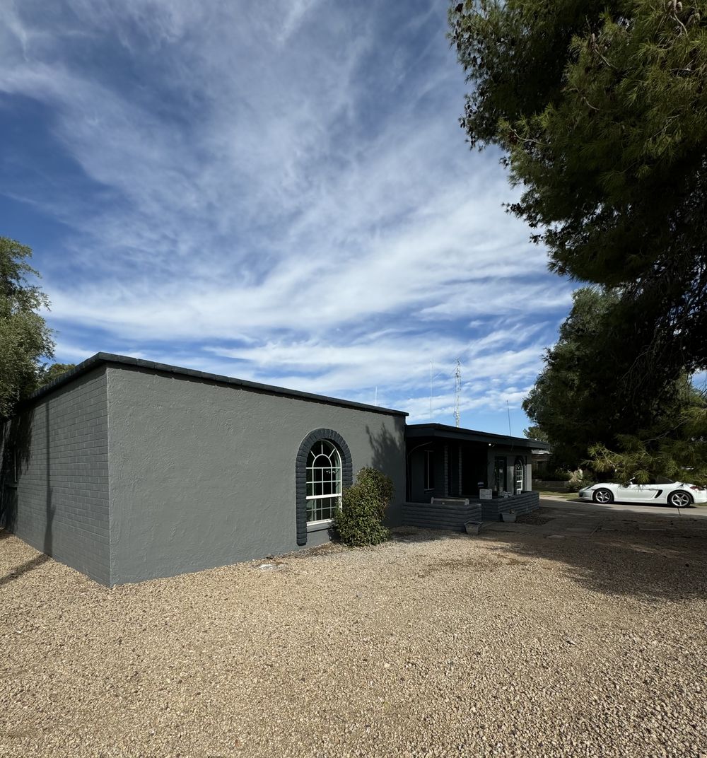 Mid-century Phoenix block home finished in charcoal grey with white arched window trim