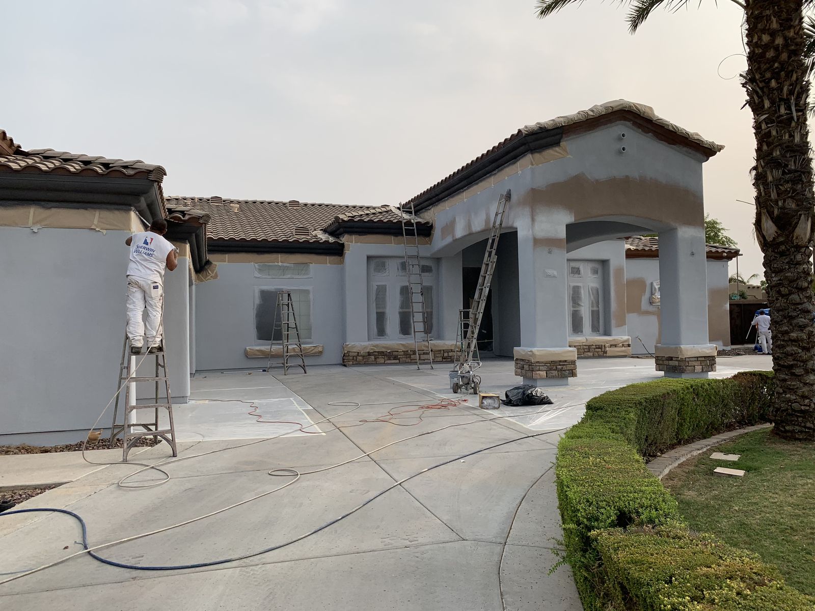 LOBOS crew spraying primer on a large Arizona stucco home