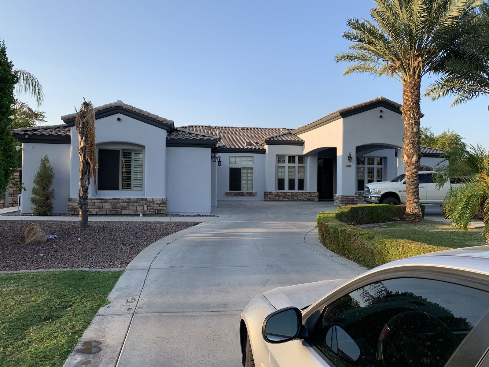 Completed Phoenix stucco home in soft white with dark bronze fascia and stone accents