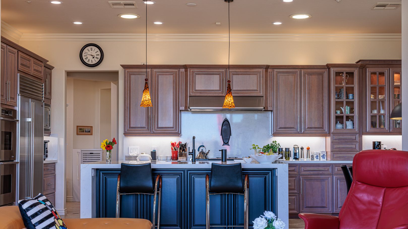 Refinished kitchen in a Phoenix home with warm stained cabinetry, a custom navy island and pendant lighting