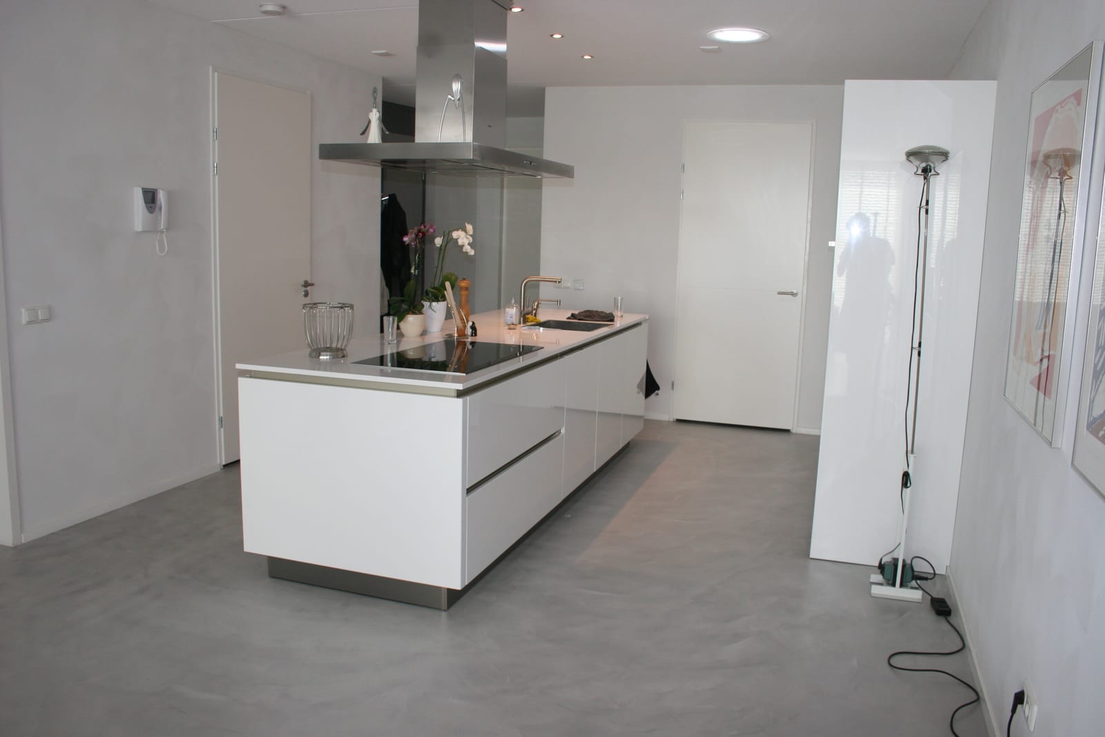Seamless microcement floor running unbroken through an open-plan kitchen with no grout lines or thresholds